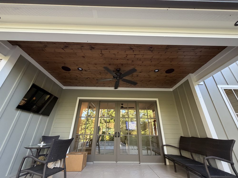 Covered porch with a wood ceiling, in-ceiling speakers, a ceiling fan and a wall-mounted outdoor TV